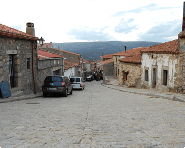 Calle empinada con fachadas de piedra y enfoscado
