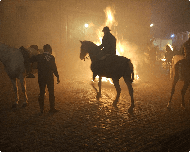 Jinete junto a una hoguera durante Las Luminarias