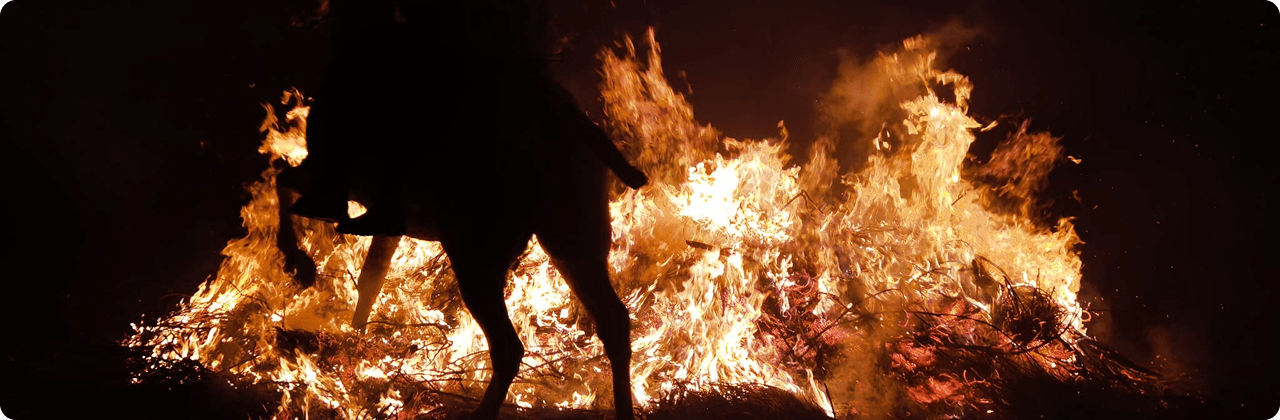 Jinetes atravesando las hogueras en Las Luminarias